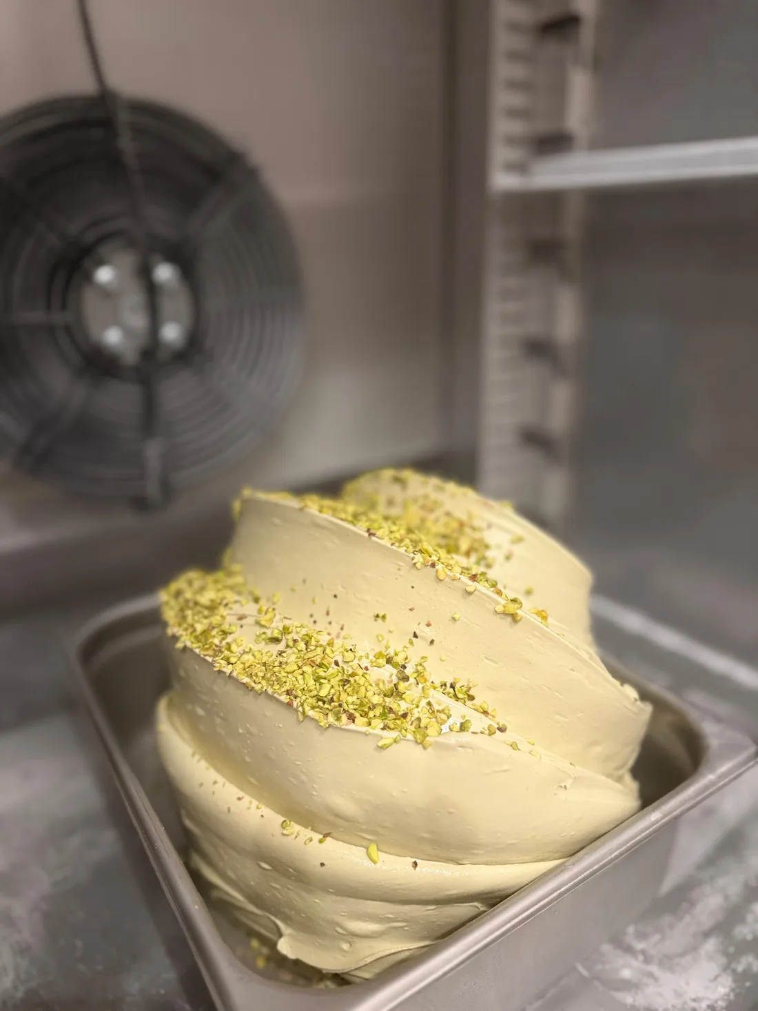 A fresh pan of pistachio gelato topped with crushed Bronte pistachio
